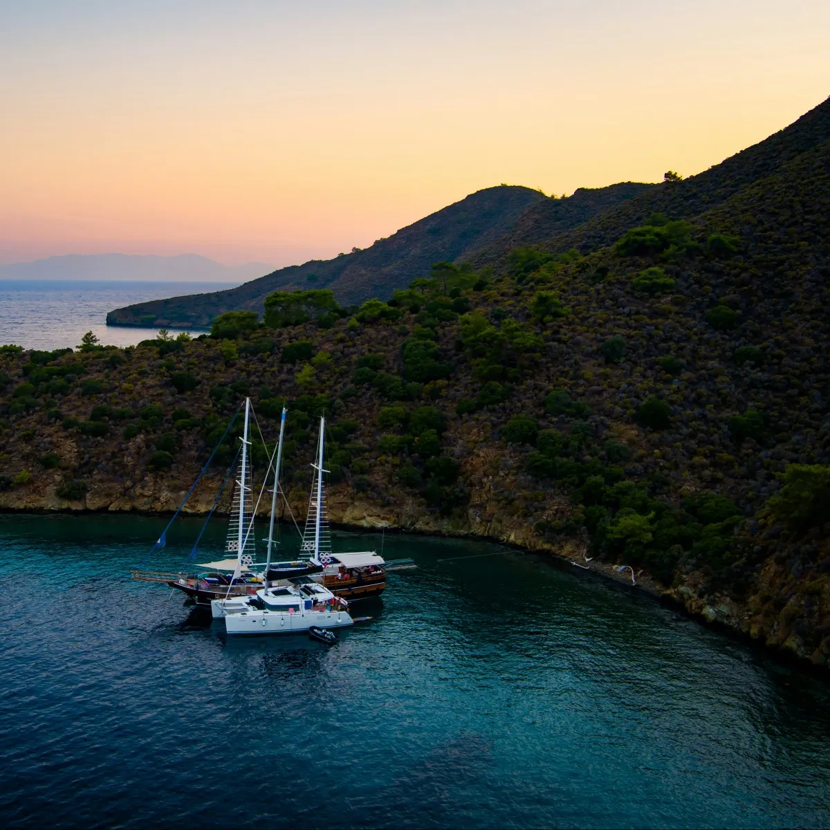 A wooden gulet at anchor in a quiet cove at dusk, Turkish coast
